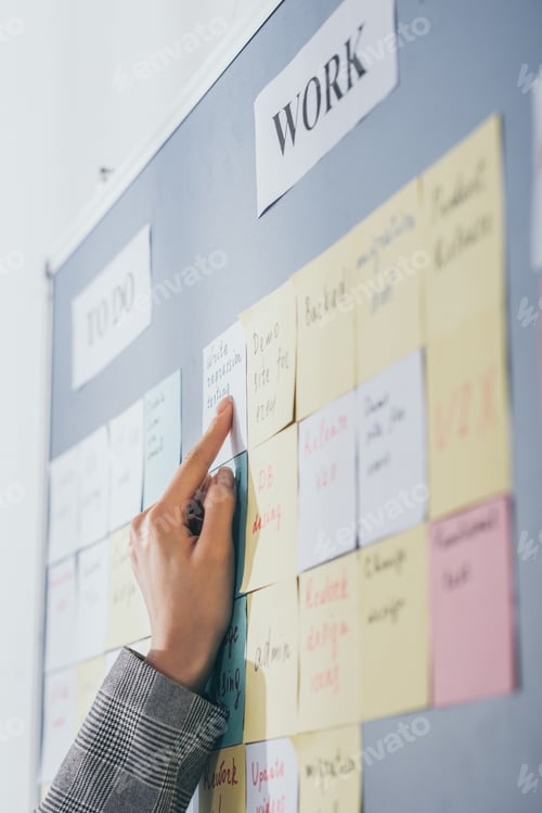 Preview: selective focus of scrum master pointing with finger at sticky note with write regression testing