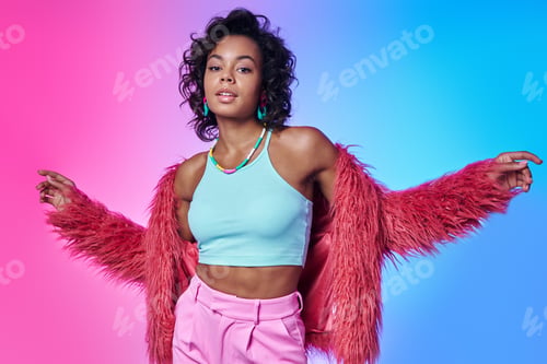 Preview: Fashionable African woman in fluffy jacket standing against colored background