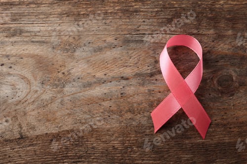 Preview: Pink ribbon on wooden background, top view with space for text. Breast cancer awareness concept