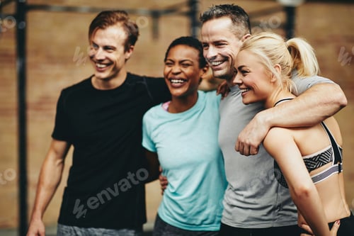 Preview: Laughing group of diverse friends standing together in a gym