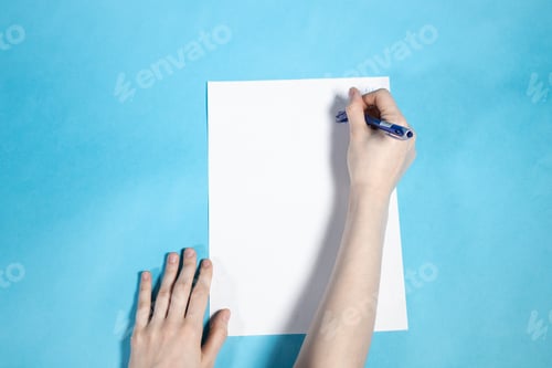 Preview: above view of hand writes on blank white paper