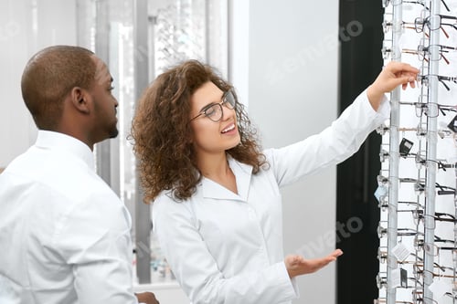 Preview: Young doctor helping to choose right eyelense