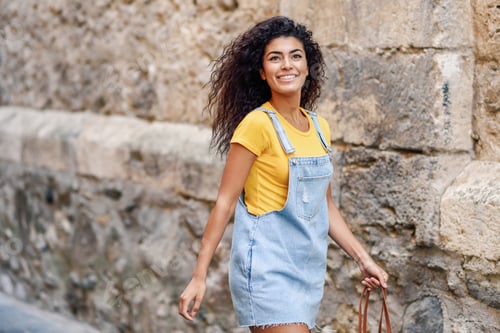Preview: Young black tourist woman with curly hairstyle outdoors