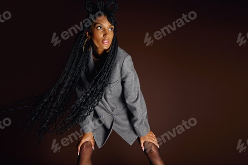 Confident young woman showcases a unique fashion sense with striking long hair and a blazer