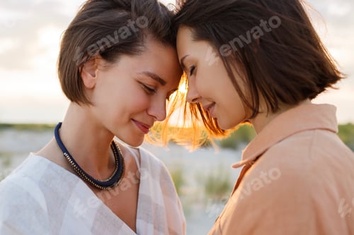 Preview: Two women standing face to fase on beach