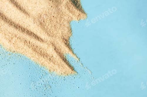 Preview: Sand heap texture on blue background. Concept summer beach surface