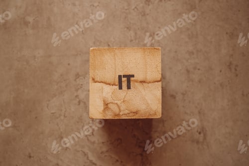 Preview: IT acronym text on wooden cube block on the old concrete table background