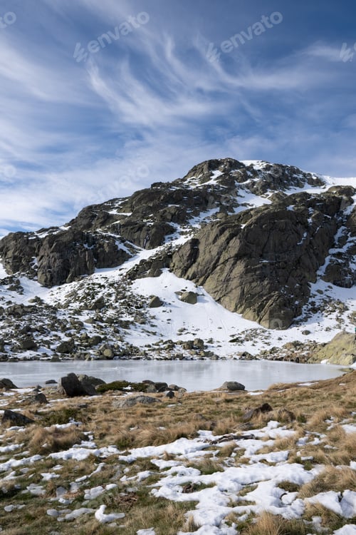 Preview: Beautiful scenery of a snow-covered landscape with rocky cliffs under a cloudy sky