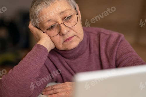 Preview: a woman sits at a table and watch a movie at a laptop, the concept of social distance