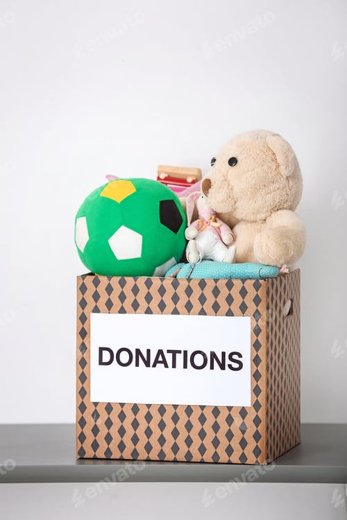 Preview: Donation box with toys on table against light background