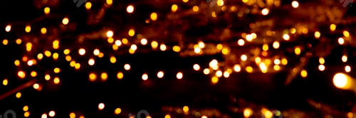 Preview: Blurry garland lights on a dark background. Festive Christmas and New Year background. Soft focus