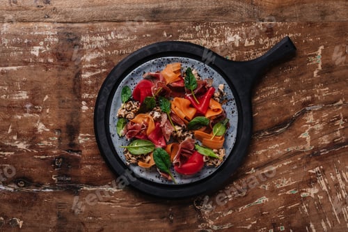 Preview: top view of fresh tasty salad with mussels, root vegetables and jamon on wooden table
