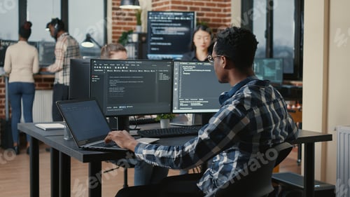 Preview: Portrait of programer fixing glasses while typing on laptop smiling satisfied about compiling