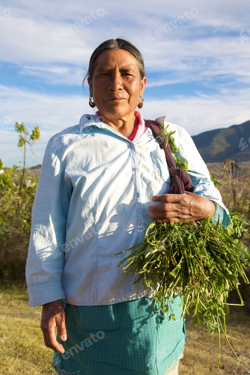 Preview: Woman proudly holding fresh harvest in rural landscape