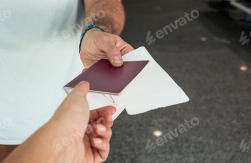 Preview: closeup traveler's hand showing passport and boarding pass