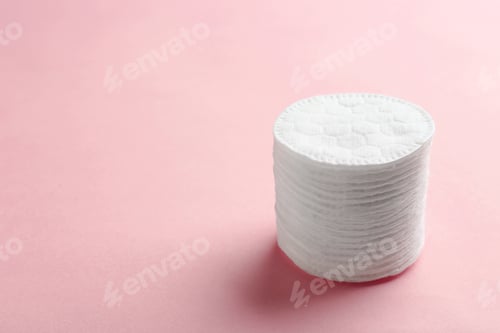 Preview: Stack of cotton pads on color background. Space for text
