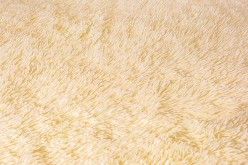 Preview: Faux fur background texture close-up light color. Artificial fur with short pile blank background