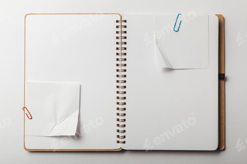 Preview: top view of opened notebook with sticky notes and paper clips on white background