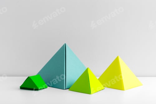 Preview: Colorful geometric pyramids in various sizes displayed on a white surface