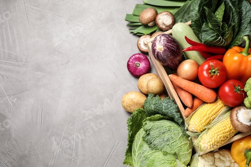 Preview: Flat lay composition with fresh vegetables on grey table, space for text