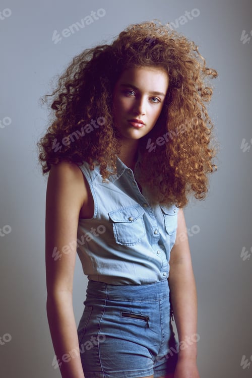 Preview: Teen female fashion model with curly hairstyle in denim shirt