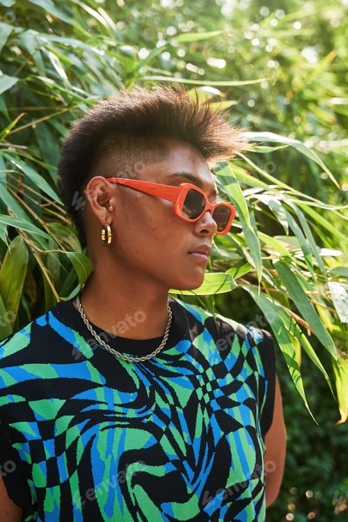 Preview: Asian transgender person near lush bush