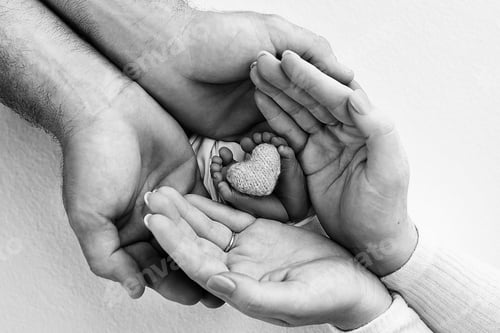 Preview: Children's leg in the hands of mother, father, parents. Feet of a tiny newborn.