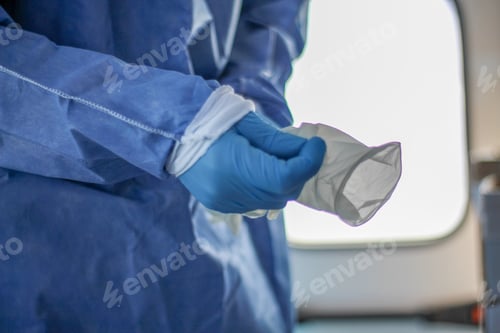 Preview: Medical Professional Prepares with Gloves and Gown