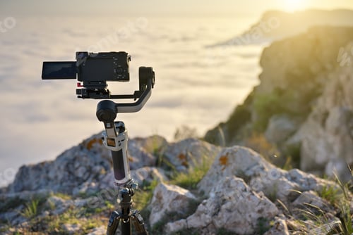 Preview: Professional Camera on Gimbal Stabilizer and Tripod in Mountains at Golden Hour Sunset Filmmaking