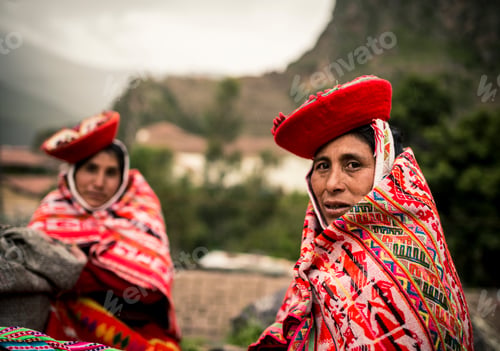 Preview: Colorful Andean tradition captured as local women clad in vibrant attire share a moment.