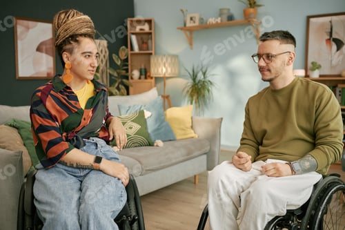 Preview: Man and Woman Using Wheelchairs Chatting Indoors