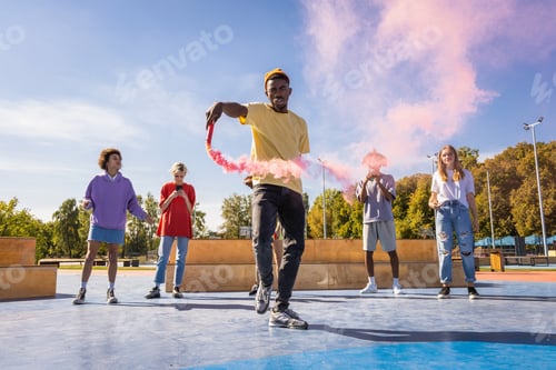 Preview: Multiracial group of young friends bonding and dancing outdoors