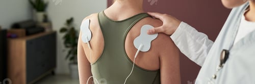 Preview: Doctor Adjusting Electrodes On Patient's Back During Appointment