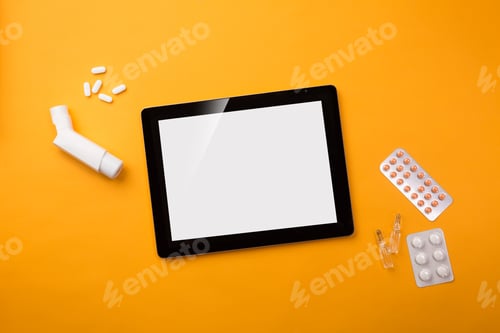 Preview: Digital tablet in doctors desk with inhaler and pills