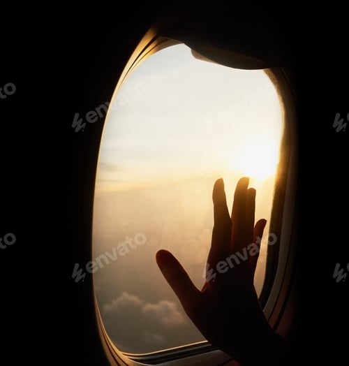 Preview: Touch the sky. Shot of an unrecognizable persons hand up against the window of a plane.