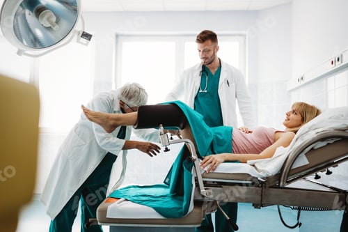 Preview: Medical team, obstetrician examining pregnant young woman in hospital