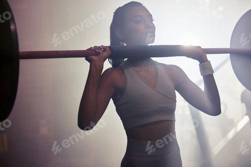 Preview: Shot of a sporty young woman getting ready to do a barbell overhead press in a gym
