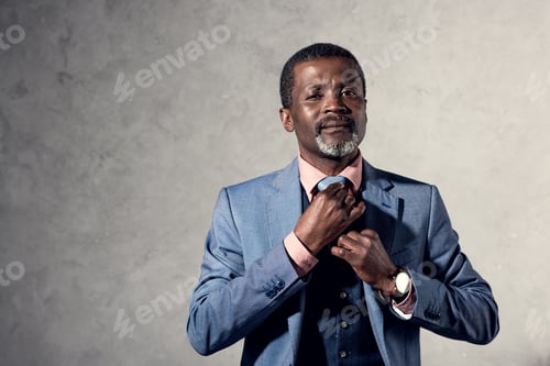 Preview: middle aged african american man fixing tie