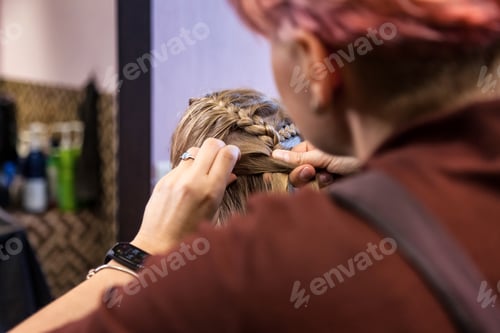 Preview: Hair salon, Hairdresser makes hairdo for baby in barber shop at mirror.