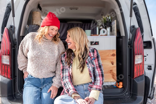 Preview: Two women laughing and enjoying their road trip in a camper van
