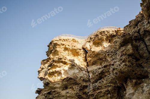 Preview: Sunlit cliffside at coastal resort