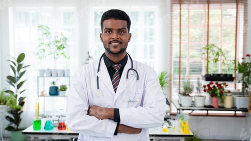 Preview: Mature Male Doctor Wearing white Coat Standing in Hospital Corridor.