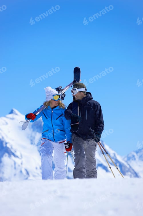 Preview: Couple walking with skis over shoulder