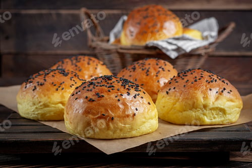 Preview: Homemade freshly baked plain golden brown soft hamburger buns topped with sesame seeds