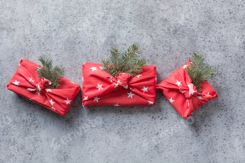 Preview: Christmas gifts wrapped in red textile with natural decor. Sustainable gifts.