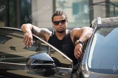 Preview: An African-American man poses near his car