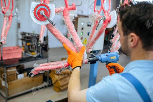 Preview: Bicycle factory, worker holds pink kid's bike