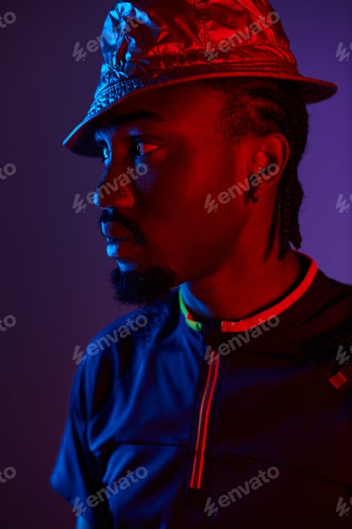 Vista previa: A stylish young African American man highlights modern fashion in a vibrant neon studio setup