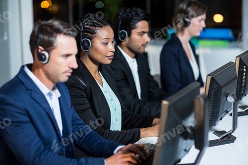 Preview: Group Of Business Colleagues With Headsets Using Computer At Office Desk