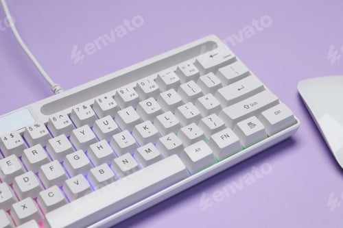 Preview: White keyboard with RGB lighting and mouse on violet background, closeup